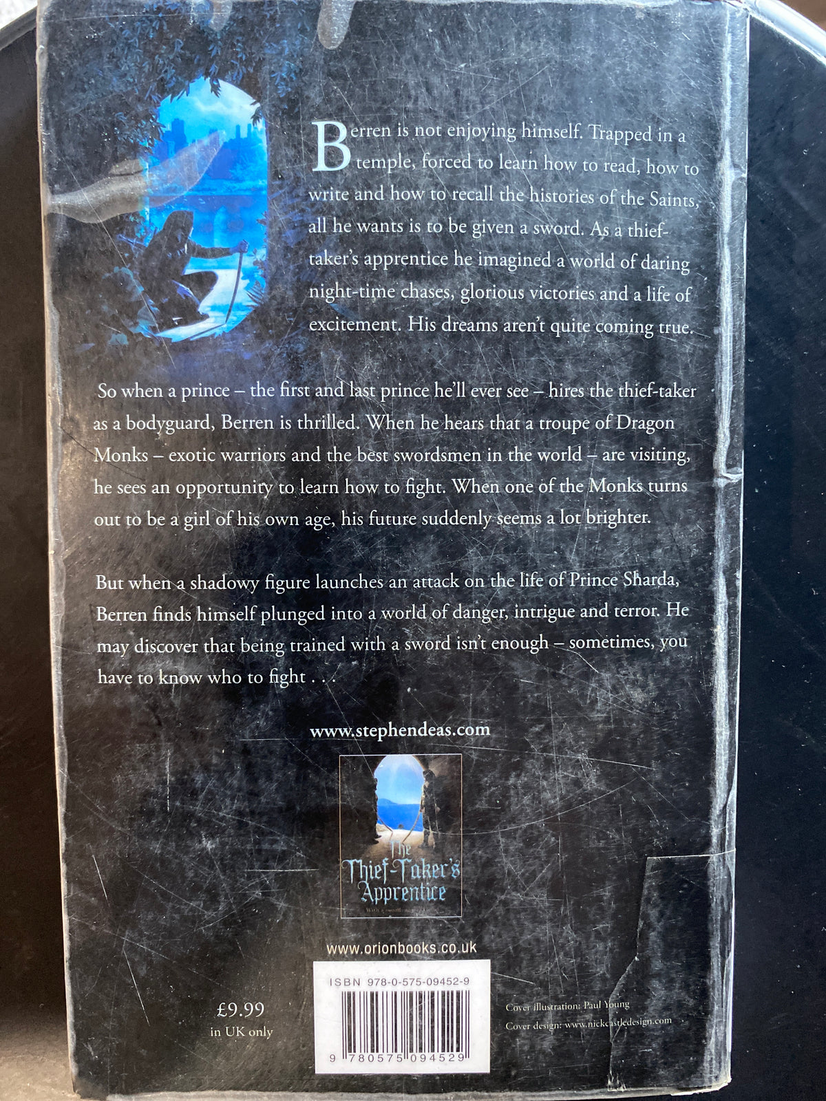 The back cover of the book 'Thief-Taker's Apprentice' by Stephen Daldry, featuring a dark background with a blue illustration of a sword and text detailing the book's plot.